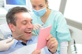 man admiring his smile in a mirror