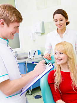 Dentist, patient, and assistant enjoying friendly rapport