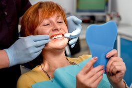 An older woman examining her smile