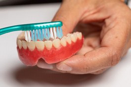 Man brushing his dentures