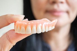 Woman holding dentures