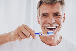 man brushing his teeth 