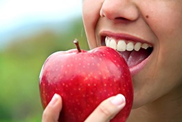 Close up of woman biting into red apple