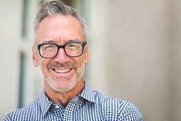 Man smiling after learning about cost of dental implants