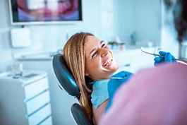 Woman smiling at dentist during oral exam