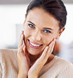 Brunette lady smiling while holding cheeks