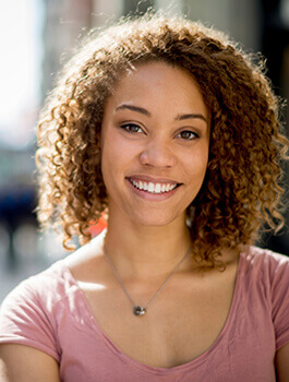 Curly haired brunnette lady smiling after cosmetic dentistry in Buckhead Atlanta