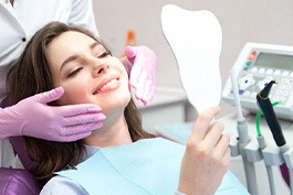 A woman admiring the results of cosmetic dentistry